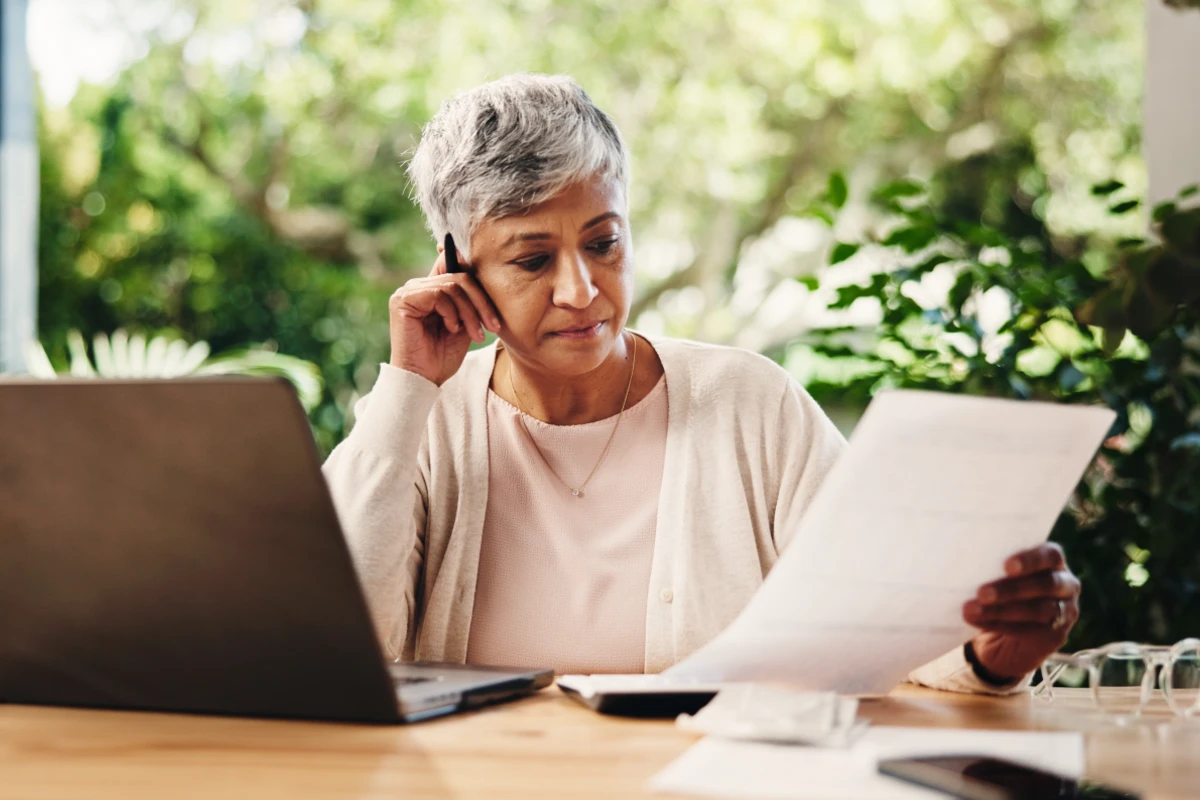 papiers-assurance-vie-deces Femme consultant les papiers assurance-vie de son mari décédé