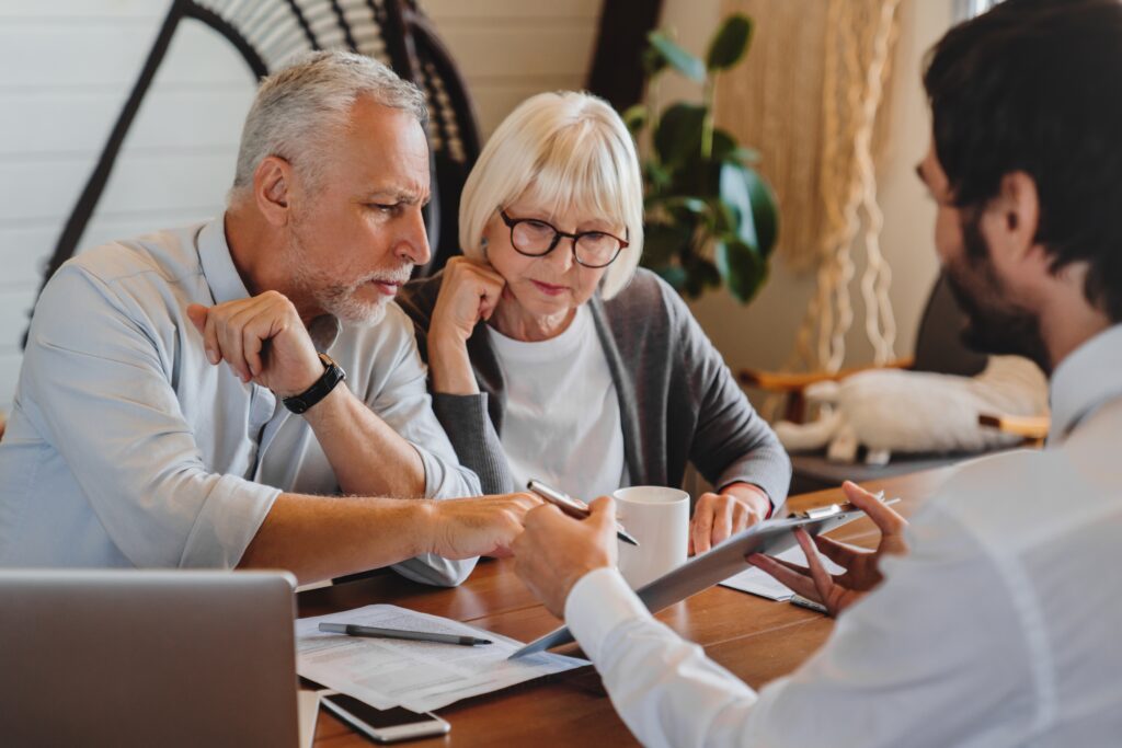 Conseiller financier présentant des stratégies de gestion de patrimoine à un couple âgé